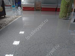 Однотонный пол с цветными чипсами, покрыт прочным защитным лаком. глянцевый пол в продуктовом магазине.